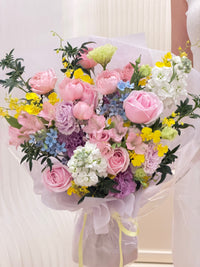 Close-up of light pink roses, blue oxypetalum, lavender lisianthus and yellow Oncidium orchids in a mixed flower bouquet