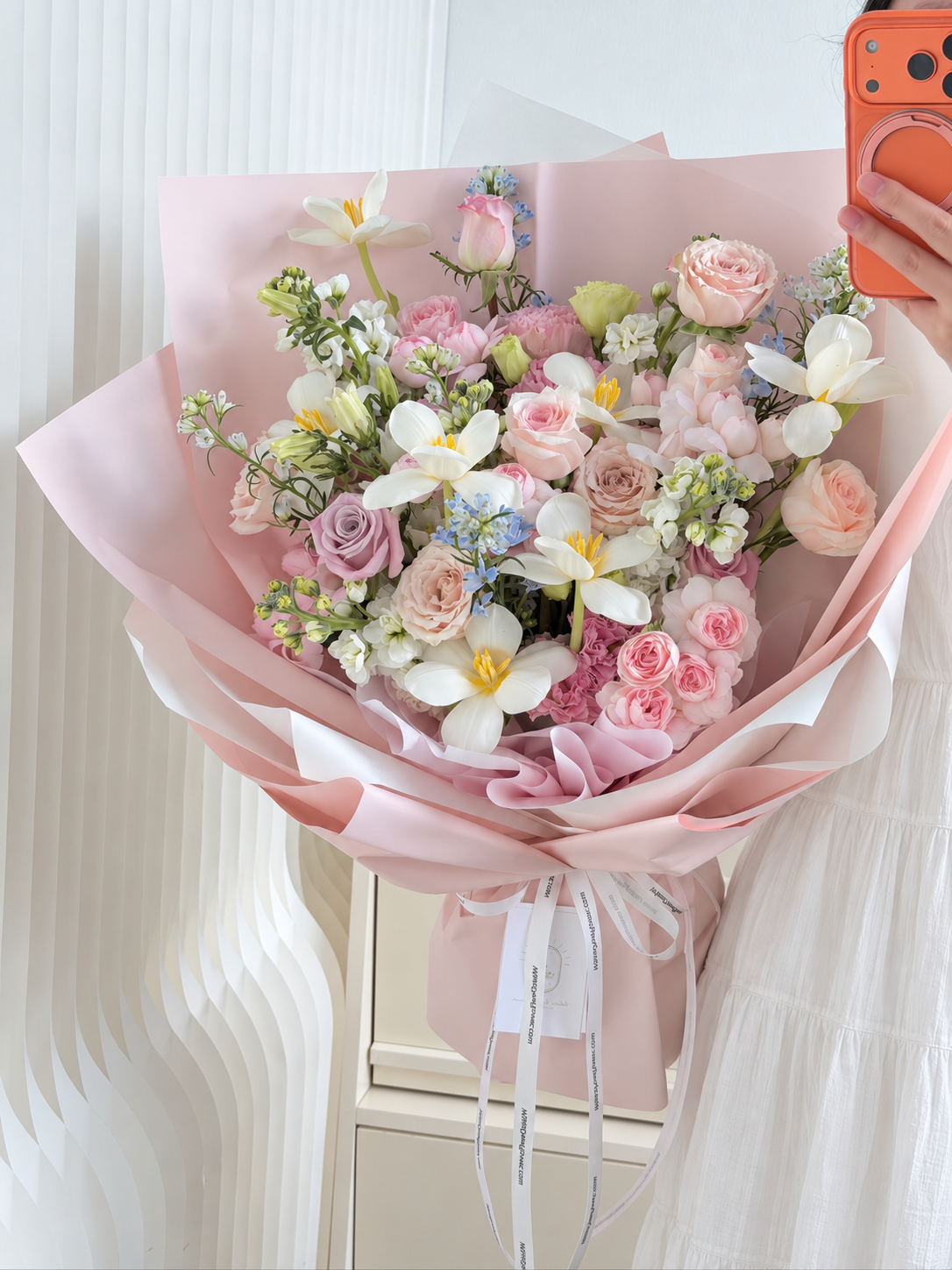 Close-up of premium Quicksand, Menta and Fairy Kiss roses with white tulips and delicate blue delphiniums