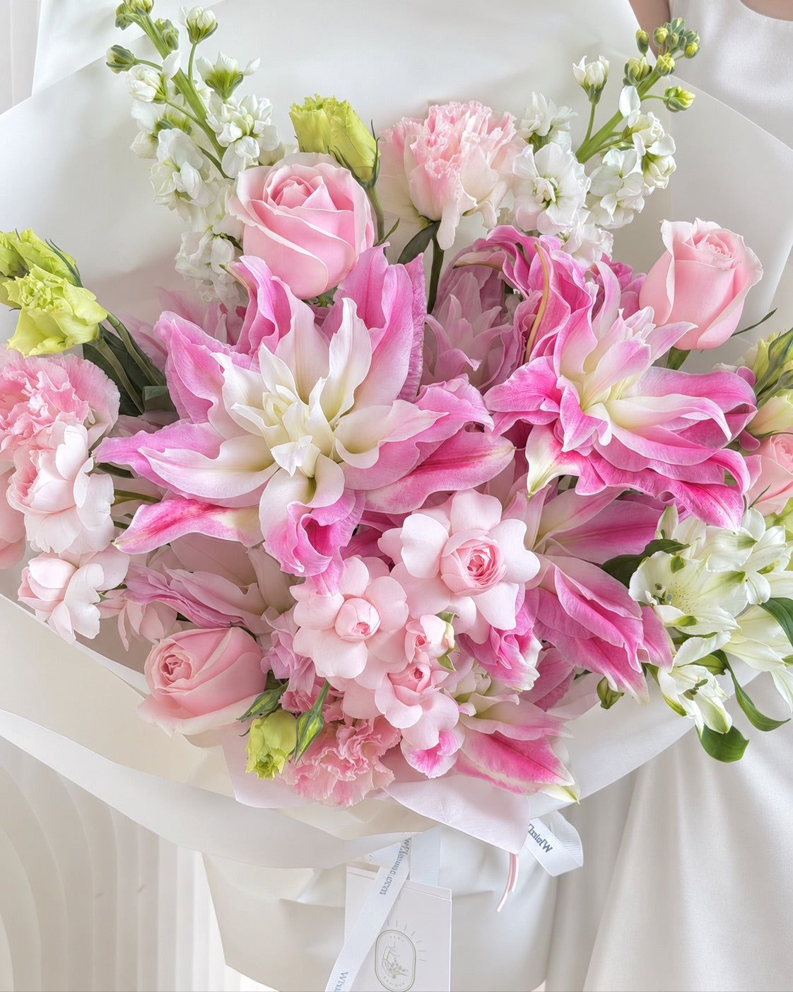 Close-up of pink and white double lilies, soft pink roses, Fairy Kiss spray roses and delicate white flowers
