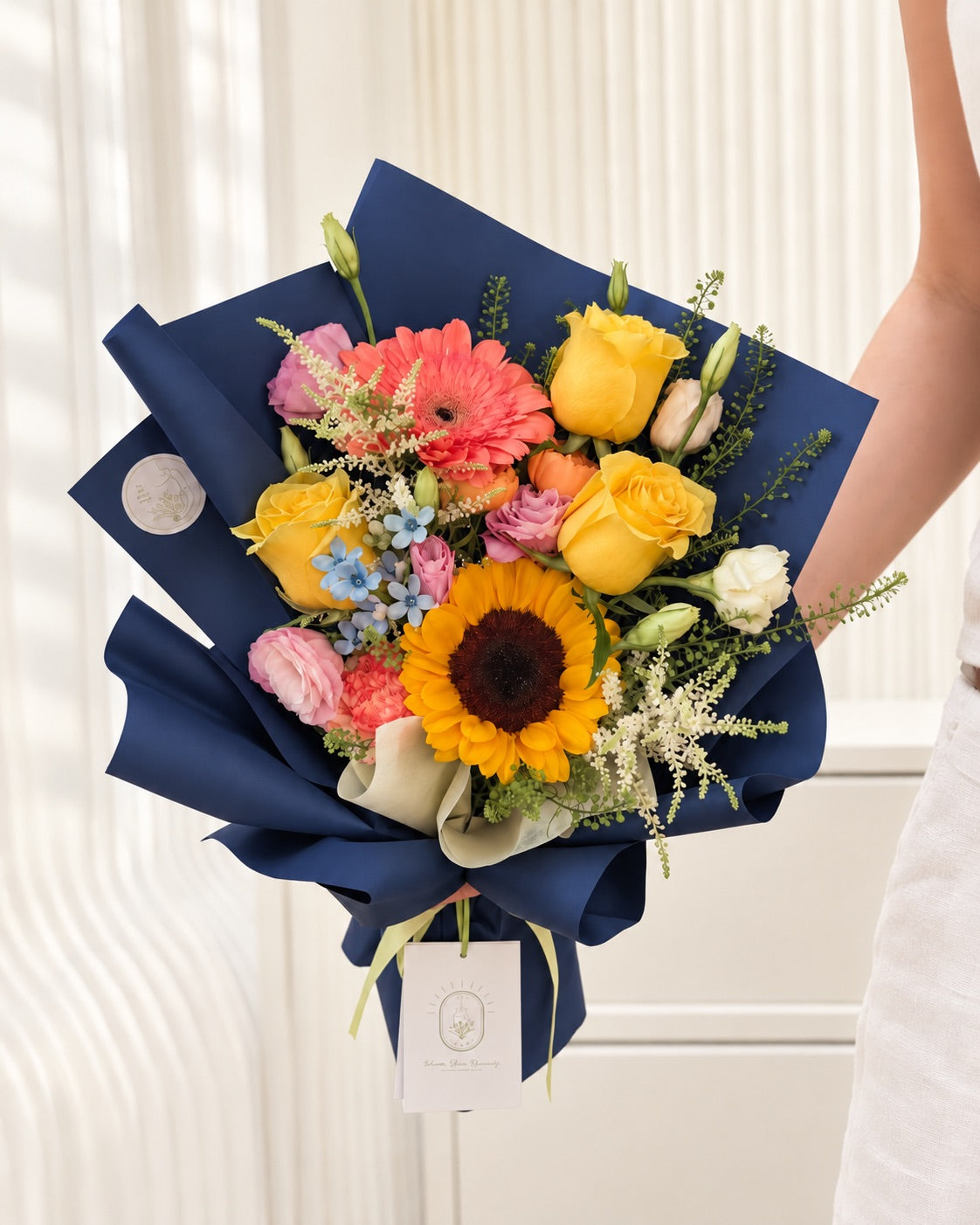 Bright Futures sunflower graduation bouquet with yellow roses, coral gerbera, pink lisianthus and navy blue wrapping by White Dew Flower Singapore.
